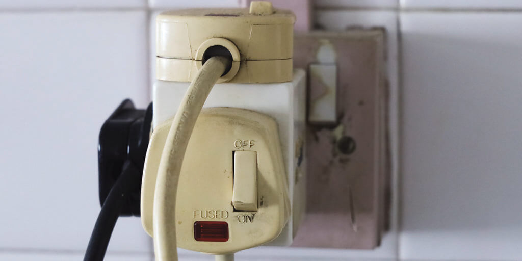 Household multi socket plug overloaded with old plugs.