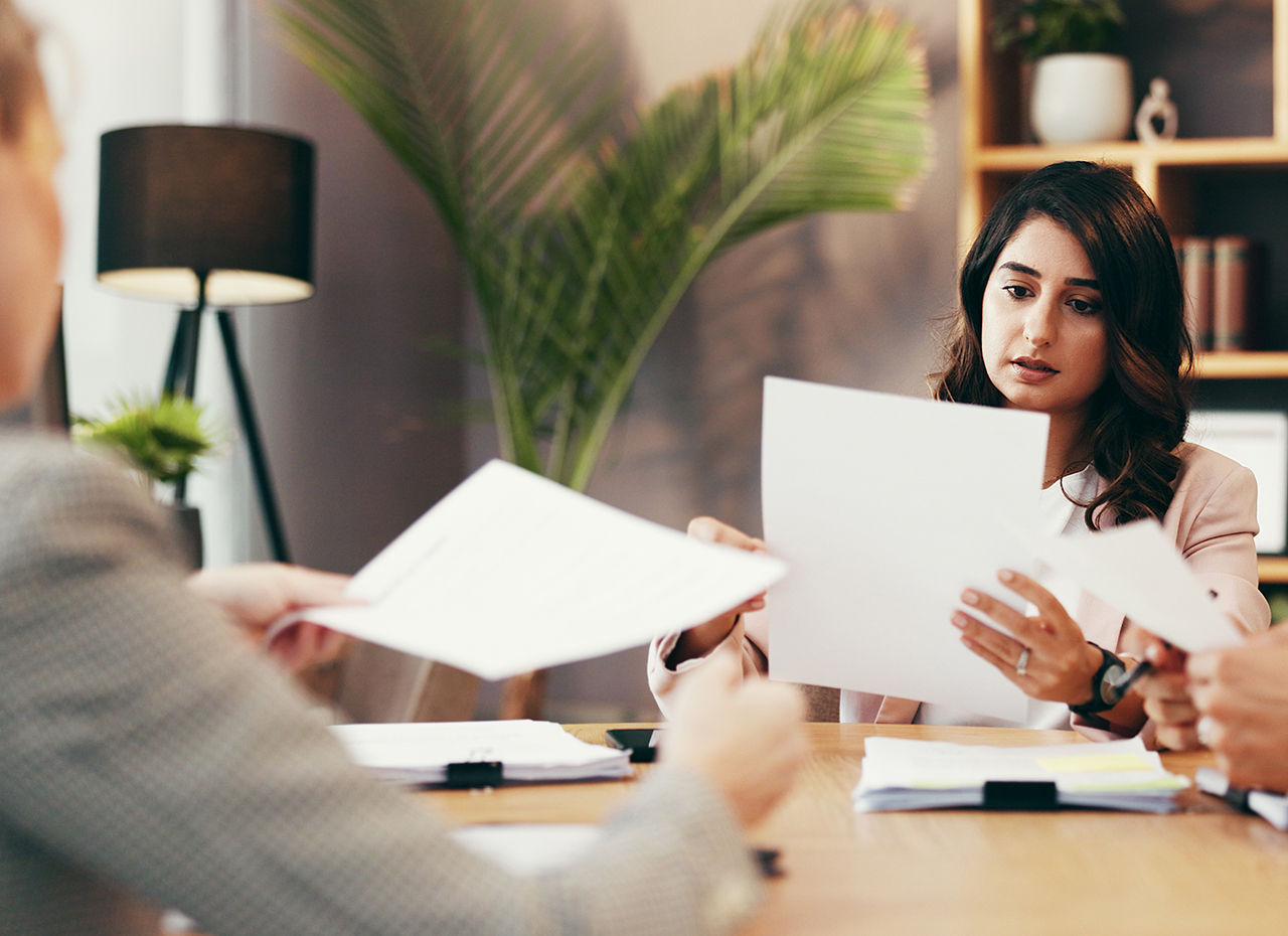 Clients and lawyer and reading documents in office for legal information and negotiations.
