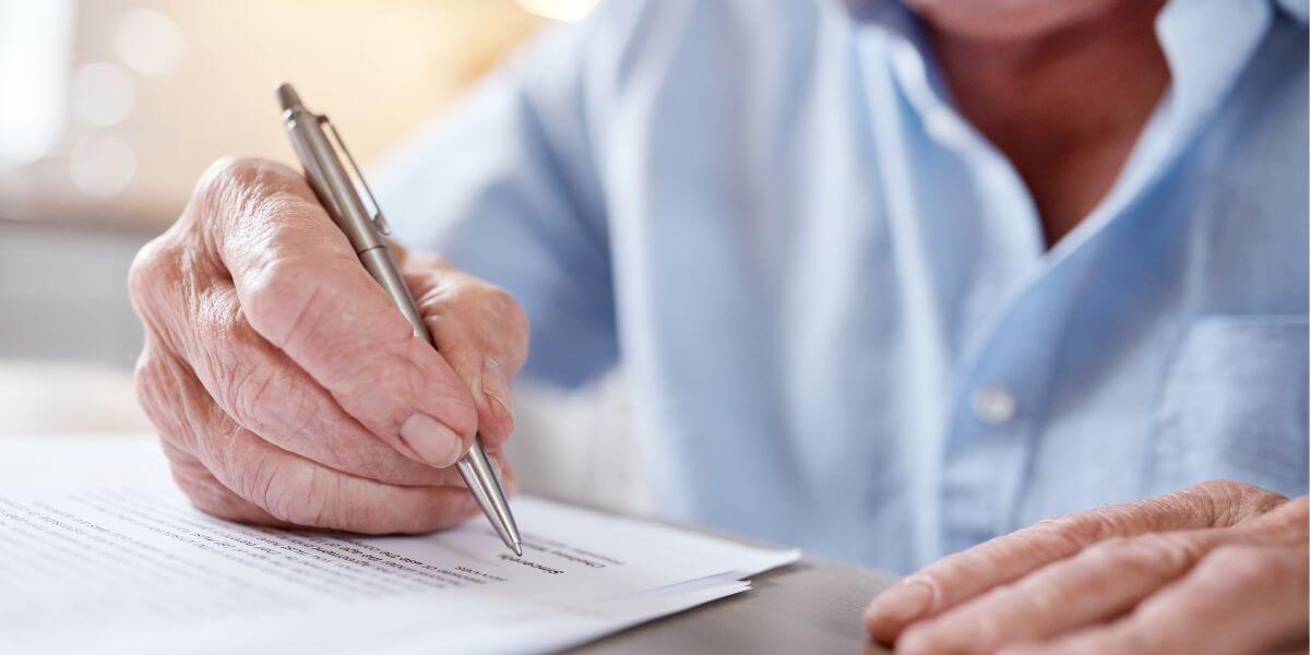 Elderly Man Signing Paperwork