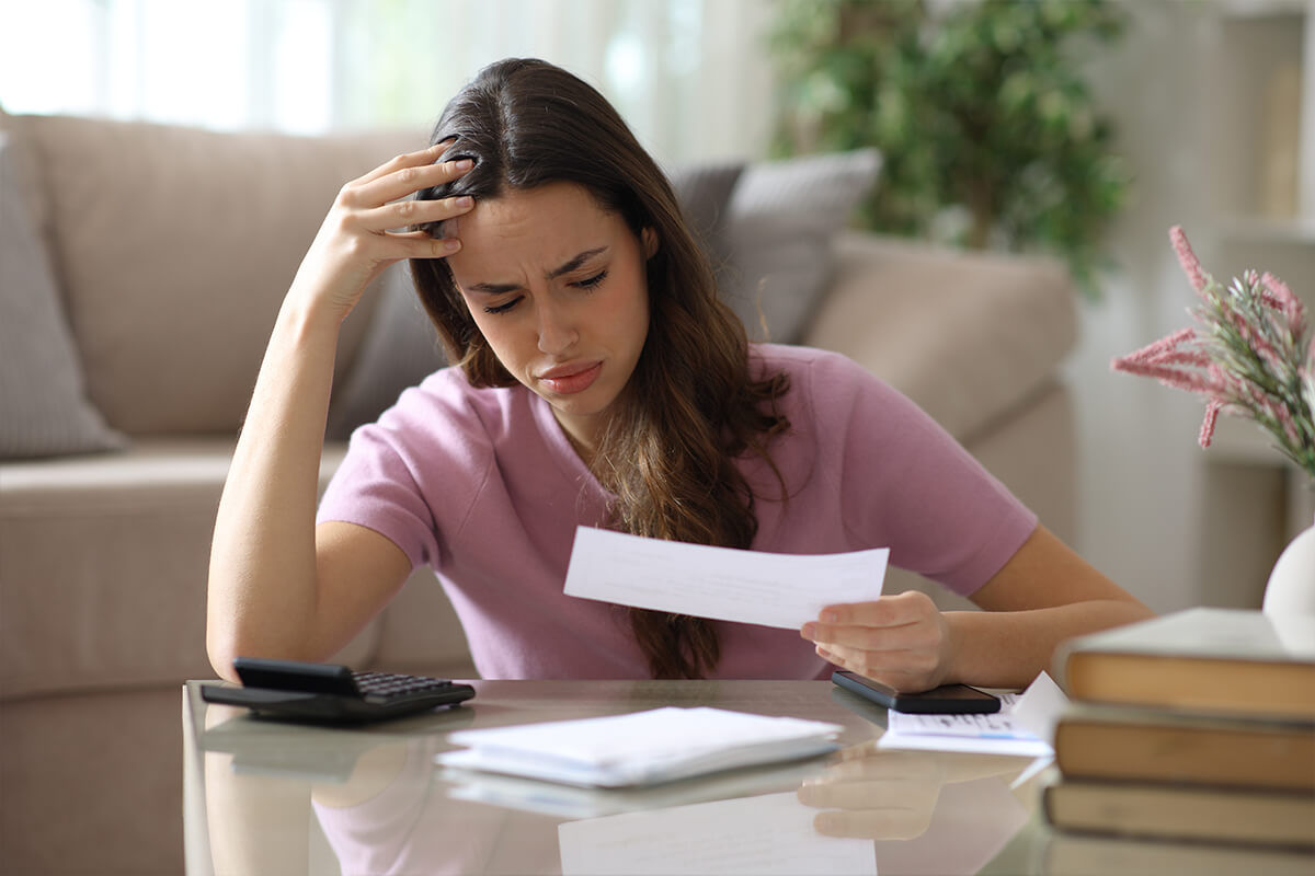 Worried woman checking invoice